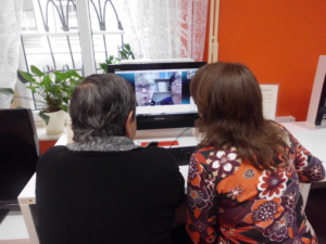 Na zjćeiu siedza dwie koniet przed komputerem, na ekranie widać dwie inne kobiety, odbywa się wideo konferencja