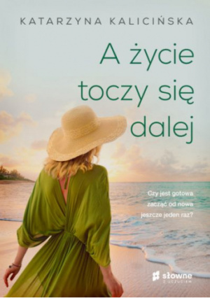 Okłądka kiążki A życie toczy się dalej Katarzyny Kalicińskej, Mmłoda konieta w zielonej letniej sukience i kapeluszu stoi nad brzegiem morza i patrzy w dal